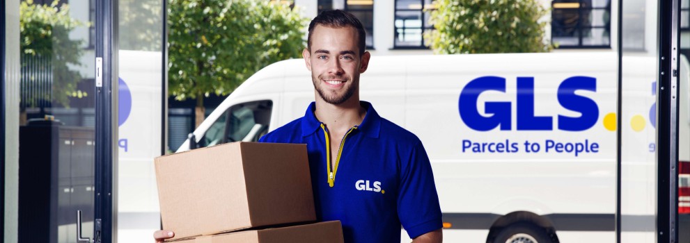 A delivery man holds a parcel in front of his van