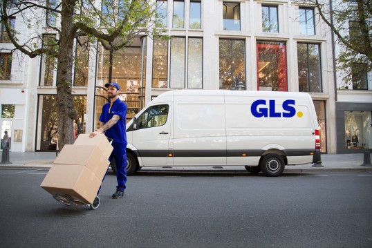 GLS long range truck drives on a field between a forest and a field