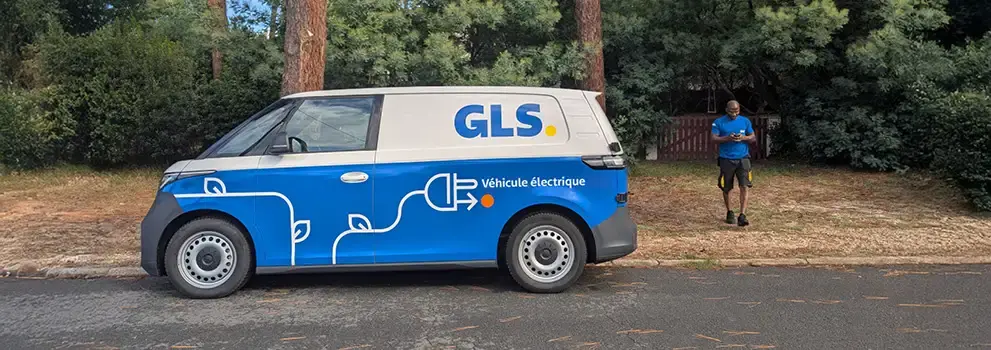 A GLS delivery driver uses an electric van in GLS colors