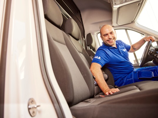 GLS futár házhoz megy a csomagért.