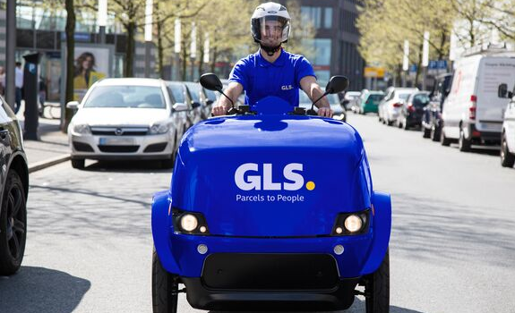 Kurier na e-skuterze dostarcza paczki Klientom